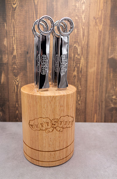 Six wrench handle steak knives displayed in a workshop setting
